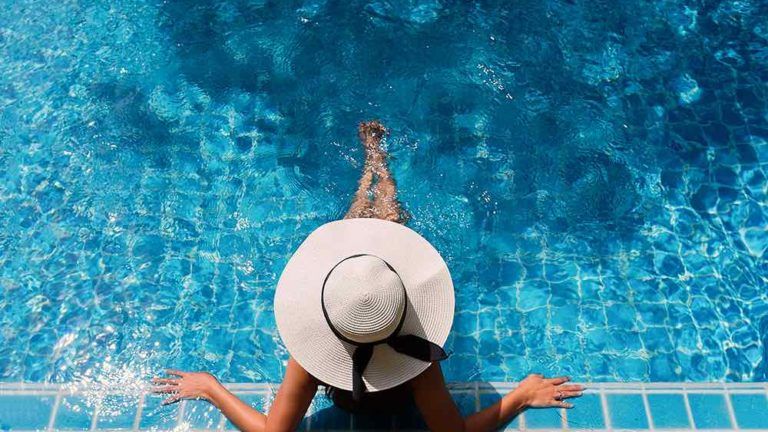 women sitting in a pool with a hat on